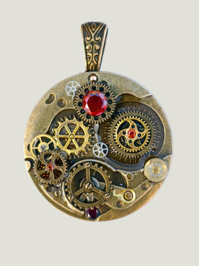 recto Pendentif en alliage cuivre et laiton, orné d’engrenages et de 4 grenats avec bélière gravée bronze