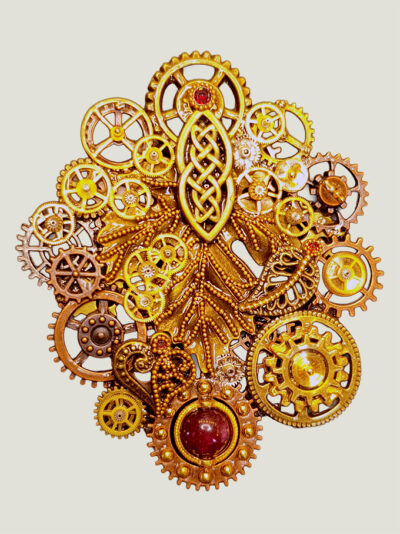 Recto d'une Broche composée d'engrenages et pièces en alliage ton dorés et cuivre avec des grenats et une perle calcédoine montée sur un axe