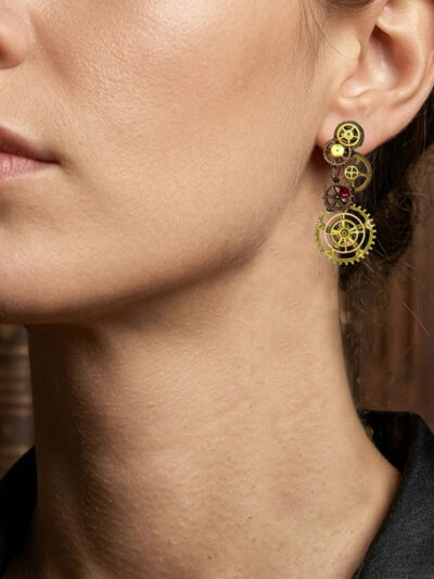 Boucles d'Oreilles composées de 5 engrenages collés verticalement avec un grenat sur chaque boucle portée sur l'oreille gauche d'une femme brune au cheveu long attachés dont on ne voit que le bas du visage