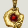 recto du pendentif en laiton fondu et formé en pépites avec un cabochon de verre rouge au centre