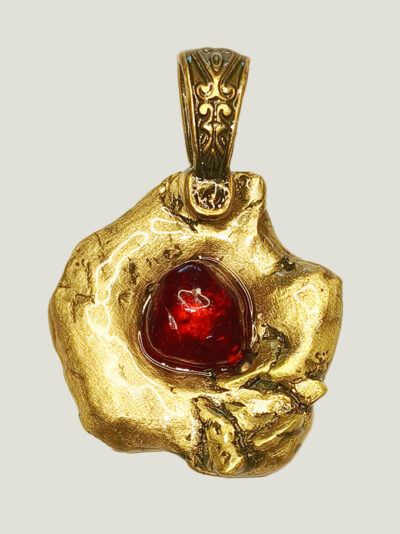 recto du pendentif en laiton fondu et formé en pépites avec un cabochon de verre rouge au centre