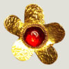 Recto d'une Broche en laiton martelé en forme de grosse fleur avec un cabochon de verre rouge au centre entourée de petites perles dorées