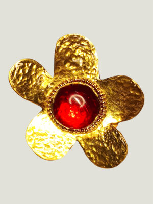 Recto d'une Broche en laiton martelé en forme de grosse fleur avec un cabochon de verre rouge au centre entourée de petites perles dorées