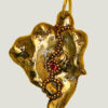 Recto pendentif pépite laiton fondue ornée de petites perles dorées et d'une grenat avec anneau en laiton