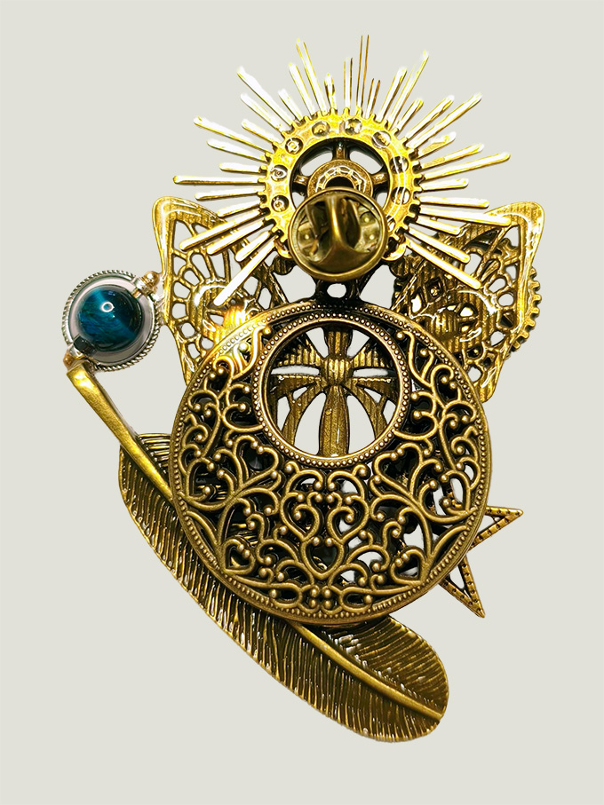 Printalia-verso verso d'une broche faite avec engrenages et des pièces en laiton cercle et plume, soleil avec une perle verte montée sur un axe sur le côté et une attache