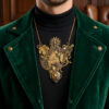 recto pendentif steampunk engrenages alliage salamandre couleur bronze ornés de 10 grenats attaché à 2 chaines doré porté par un homme brun dont on ne voit que le bas du visage avec une petite barbe et qui porte une veste en velours vert foncé et une chemise noire