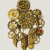 recto Broche Steampunk composée d'un engrenages et d'éléments divers en alliage bronze Ornée de 4 grenats et de petites perles dorées.