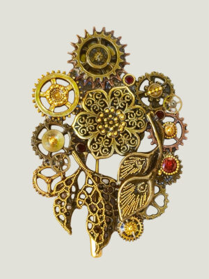 recto Broche Steampunk composée d'un engrenages et d'éléments divers en alliage bronze Ornée de 4 grenats et de petites perles dorées.